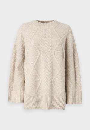 Beige neulepaita, jossa on pyöreä kaula-aukko, esittelee teksturoituja timanttimalleja sekä ribbausteet hihoissa ja helmassa. Mukava ja paksu neulontasuunnittelu.