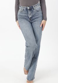 Jeans blu a vita alta con effetto slavato, dotati di cinque tasche, chiusura con bottoni e gambe dritte con una leggera elasticità per il comfort.