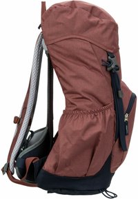 Mochila de tela marrón rojizo con un gran compartimento principal, fondo en azul marino, panel de malla, correas ajustables y cincha elástica en la parte superior.