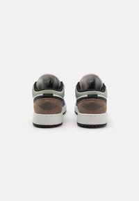 Sneakers med överdel i läder och mocka i grön, marinblå och brun. Vit mellansula med svart yttersula och märkesdetaljer på hälen.