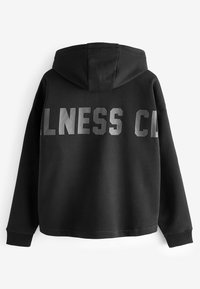 Black hoodie with a lined hood, featuring large, reflective block lettering on the back. Made of soft, textured fabric with ribbed cuffs.