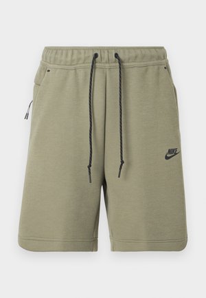Olivově zelené kraťasy Nike s černým stahovacím šňůrkem, elastickým pasem, bočními kapsami a logem Nike na levé noze.