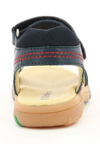 Sandale bleue avec une tige texturée et des coutures rouges ; dotée d'une sangle ajustable et d'une semelle moulée rembourrée avec un accent vert.