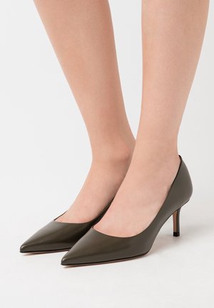 Talons hauts en cuir vert olive avec un bout pointu et un petit talon aiguille. Texture lisse, design minimaliste, ligne supérieure incurvée.