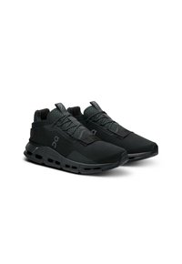 Zwarte sportschoenen met een bovenwerk van mesh, een gevoerde zool en een slank, hoekig ontwerp. Bevat veters en merkaccenten in het grijs.
