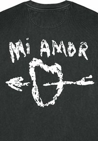T-shirt noir avec un texte graphique blanc indiquant "Mi Amor" accompagné d'un design avec un cœur et une flèche. Matière en coton avec une texture douce.