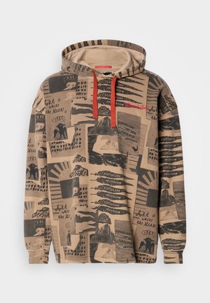 Bluza z kapturem wykonana z beżowego materiału, zdobiona kolażem czarnych grafik i wzorów tekstowych. Posiada czerwone sznurki przy dekolcie.