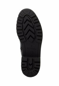 Black rubber shoe sole with a patterned tread for grip, featuring zigzag grooves and rounded edges, labeled with the brand name and size.