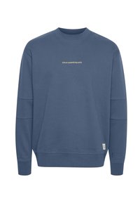 Blauwe katoenen sweatshirt met lange mouwen, geribde ronde hals en accenten aan de zijkanten. Bevat de tekst "richt op iets stevigs" in een lichte kleur.