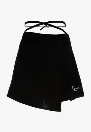 Mustvalge ümbermähkimine, millel on kõver hem, reguleeritavad ristuvad rihmad ja valge tikandiga logo alumises paremas nurgas. Sile tekstuur.