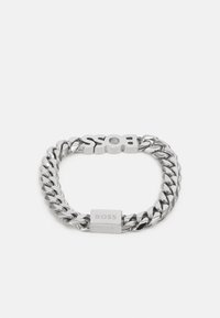 Hõbedane metallkett, millel on julge "BOSS" logo, sujuva pinnakatte ja kindla luku abil. Lülid on poleeritud jaained.
