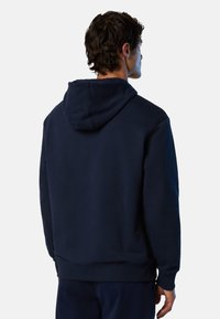 Dunkelblaue Kapuzenjacke aus weichem Stoff mit einer Kängurutasche, gerippten Bündchen und einer Kordelzugkapuze. Die Rückansicht zeigt ein minimalistisches Design.