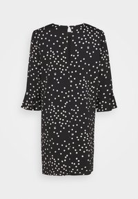 Robe noire à pois blancs, manches 3/4 avec poignets volantés, fente arrière avec fermeture à bouton au niveau du col.