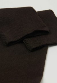 Tessuto lavorato a maglia marrone, con una texture liscia e bordi piegati. Presenta un motivo a costine e una finitura morbida.