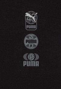 Tela negra con tres logotipos grises de Puma, que incluyen un gato saltando y diseños circulares, alineados verticalmente. Textura suave, diseño sencillo.