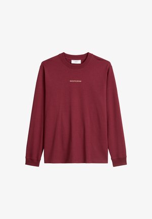 Długosamitowa, bordowa koszula z miękkiego materiału, z okrągłym dekoltem i białym nadrukiem "MARCOPOLODENIM" na klatce piersiowej.