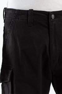 Pantalones cargo negros de material de algodón, con cierre de botón, bolsillos laterales y una textura suave. Cintura plana y detalles de costura.