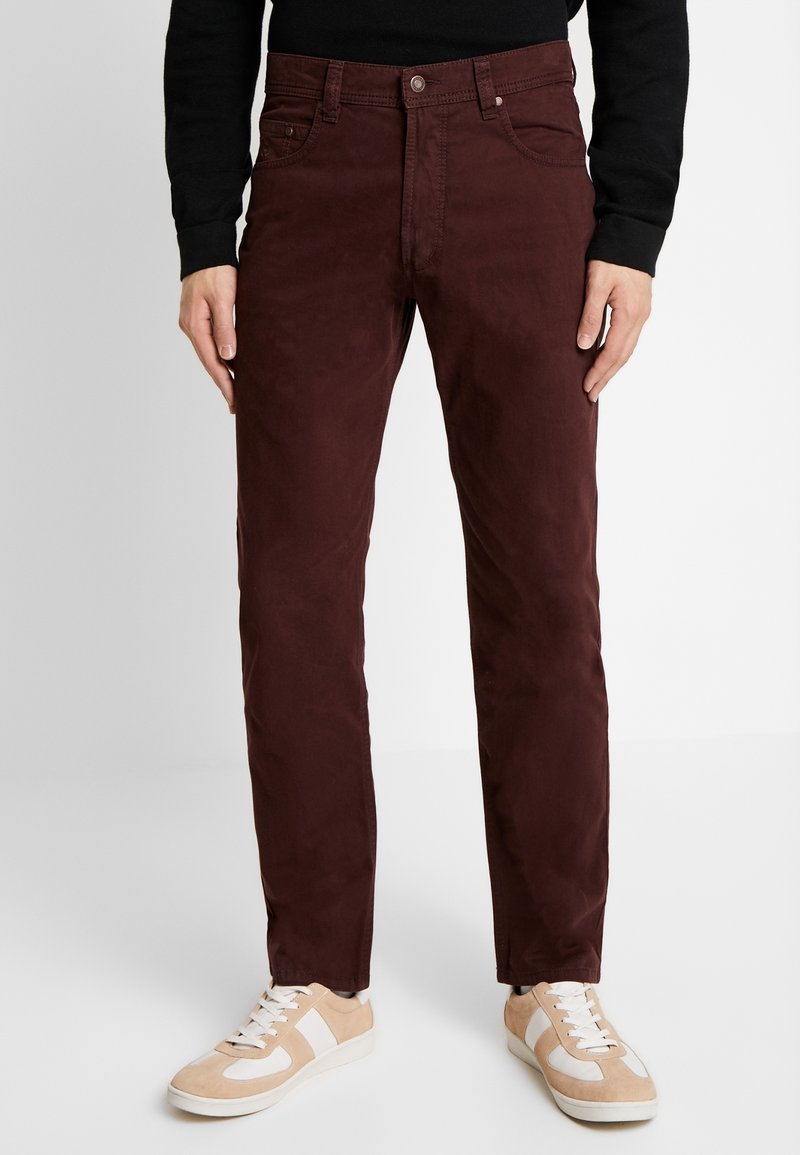 Pantaloni chino bordeaux con vestibilità slim, realizzati in tessuto misto cotone, con cinque tasche e chiusura con bottone, abbinati a sneakers beige.