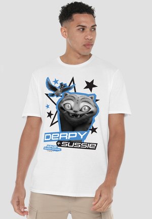 Junger Mann trägt weißes T-Shirt mit Cartoon-Katzenmotiv und Vogel, umgeben von schwarzen und blauen Sternen und dem Text "Derpy + Sussie."