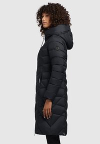 Manteau noir en doudoune avec capuche, motif matelassé diagonal, poches zippées et design ajusté, arrivant jusqu'à mi-thigh.