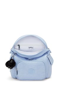 Mochila de color azul claro que cuenta con un compartimento principal con cremallera, un bolsillo delantero con el logo y un llavero de mono. Tejido suave con un acabado mate.