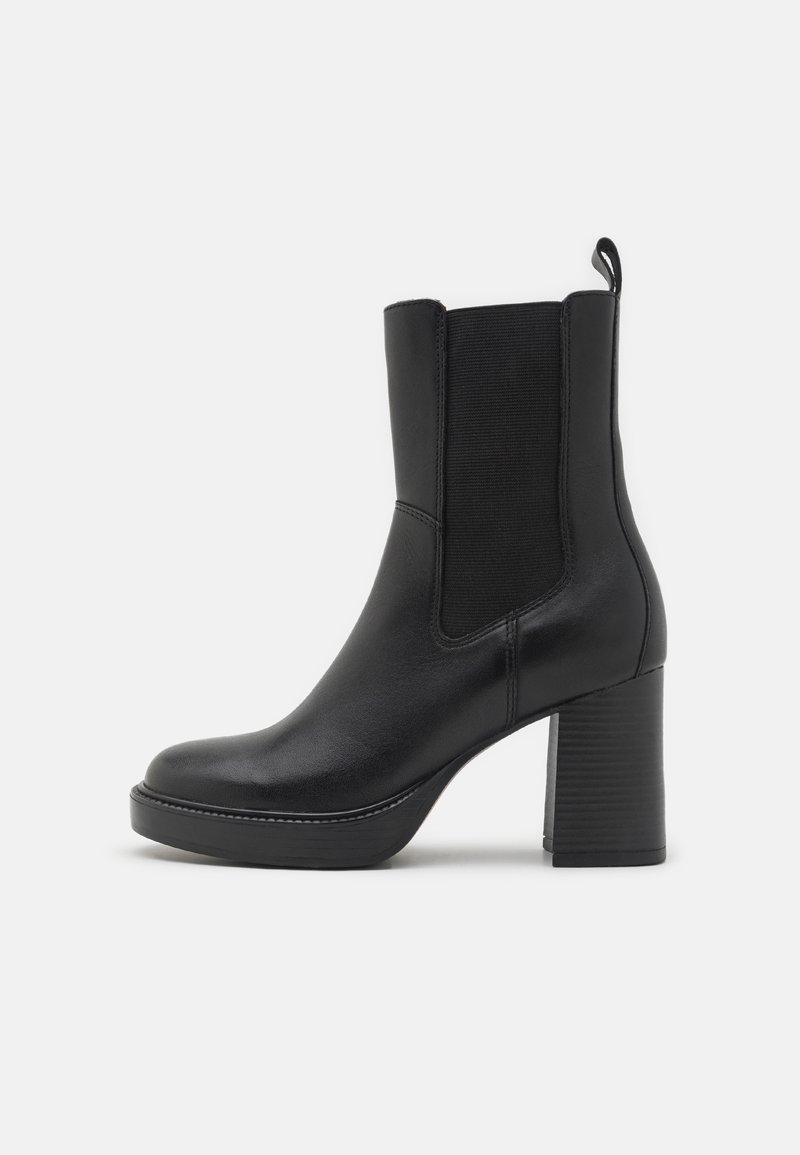 Black ankle boot made of smooth leather with a block heel, elastic side panels, and a pull tab. Features a rounded toe and minimal stitching.