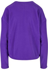 Lilla fleece genser med rund hals og lange ermer. Myk tekstur og avslappet passform med buet nederkant.