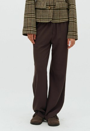 Brown wide-leg trousers made from soft fabric, paired with a plaid textured blazer featuring a button and two front pockets.