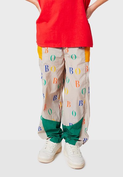 Multikleurige casual broek in lichtbeige met bedrukte letters. Bevat groene en oranje accenten bij de zakken en manchetten. Gemaakt van lichtgewicht stof.