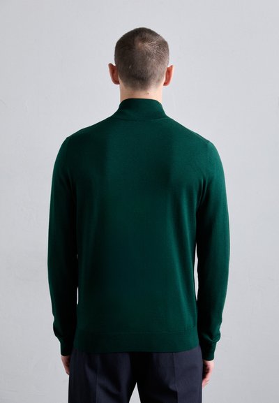 Mørkegrønn, langermet genser med høyhalset design. Glatt tekstur, ribbede mansjetter og nederkant, tettsittende silhuett.