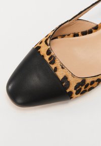Pantof cu toc înalt cu imprimeu de leopard, cu vârful din piele neagră ascuțit și un design elegant, evidențiind o textură catifelată și modele contrastante.