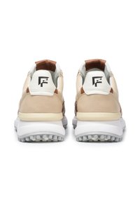 Leder-Sneakers haben ein beige-braunes Farbschema, mit einer strukturierten Oberfläche, weißen Gummisohlen und Logo-Akzenten an der Ferse.