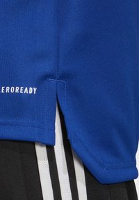 Blå sportstrøje med struktureret stof, sidespalter og hvid "EROREADY" logo. Kombination med shorts med sort og hvid strib.