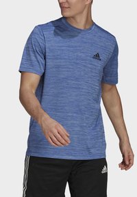 Sininen heather-kankainen urheilupaita, jossa on pyöreä pääntie ja lyhyet hihat; vasemmassa rinnassa musta Adidas-logo.