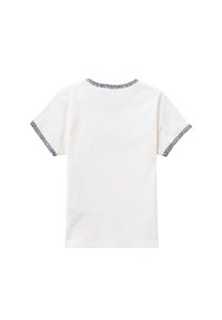 Camiseta blanca de manga corta con un acento de estampado de leopardo alrededor del escote y las mangas, mostrando una textura de tejido suave.