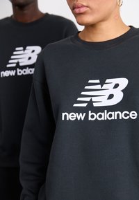 New Balance ESSENTIALS LOGO CREW UNISEX - Športni pulover - black