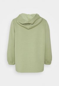 Felpa verde con una forma rilassata, maniche lunghe e cappuccio con coulisse. Tessuto morbido con una texture liscia e polsini elasticizzati.