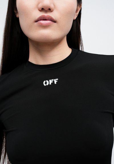 Cămașă neagră ajustată, cu o textură canelată, având imprimeu alb „OFF” pe piept. Gât rotund, mâneci scurte, design minimalist.