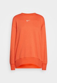 En orange sweatshirt i mjukt tyg, med rund halsringning, sänkt axel och en vit Nike-logotyp centrerad på bröstet.