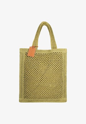 Borsa tote beige all’uncinetto con due manici e una piccola targhetta rettangolare in pelle attaccata vicino al manico.