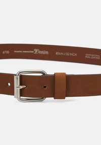 Ceinture en cuir marron avec une boucle en métal argenté, mesurant 85 cm (32 pouces), avec un logo en relief sur la sangle.