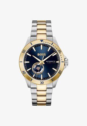 Automatisch horloge heeft een blauwe wijzerplaat met zilveren en gouden accenten, een bicolor metalen armband en een ronde wijzerplaat met markeringsdetails.