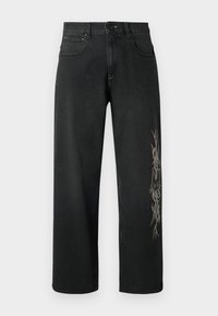 Svarta jeans i denim med lös passform, fem fickor, knappstängning och en framträdande grafisk design på vänstra benet.