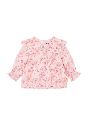 Blusa rosa con estampado floral, hombros con volantes, mangas largas, escote redondo y detalles fruncidos en los puños. Tejido de algodón suave.
