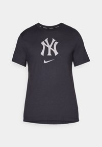 Black cotton t-shirt with a round neck, featuring a large grey NY logo and small Nike swoosh logo on the front. Short sleeves, smooth texture.