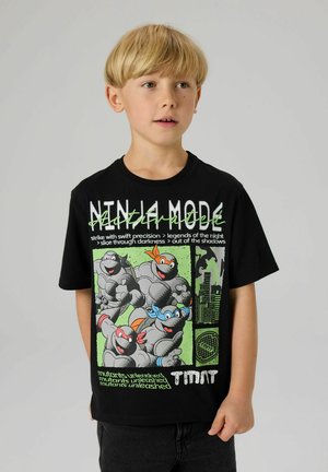 Czarny T-shirt z krótkim rękawem, ozdobiony kolorową grafiką i tekstem z Żółwi Ninja, z okrągłym dekoltem i luźnym krojem.