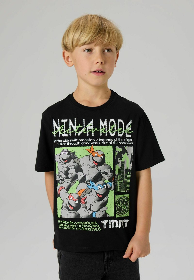 Czarny T-shirt z krótkim rękawem, ozdobiony kolorową grafiką i tekstem z Żółwi Ninja, z okrągłym dekoltem i luźnym krojem.