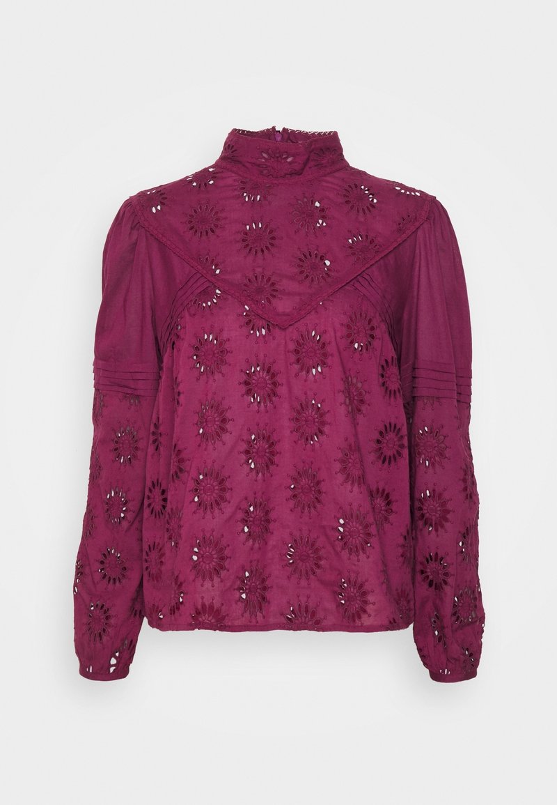 Blouse manches longues magenta à col montant, broderie florale ajourée, détails plissés aux épaules et empiècement triangulaire.
