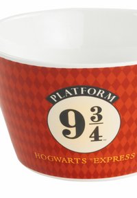 Tazza in ceramica con un motivo a diamante rosso, con la scritta "Binario 9¾" e "Hogwarts Express" in testo nero e oro. Interno bianco lucido.