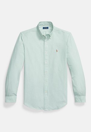 Camicia verde chiaro con bottoni, caratterizzata da sottili righe bianche verticali, colletto appuntito e un piccolo logo ricamato sul petto.